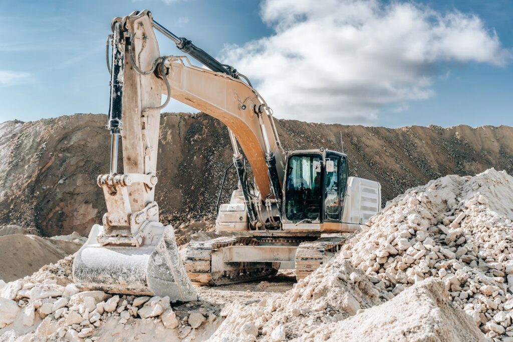 Caterpillar excavator with large bucket on construction site or quarry. Mining heavy machinery detai